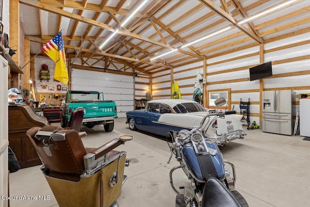 garage featuring stainless steel refrigerator with ice dispenser