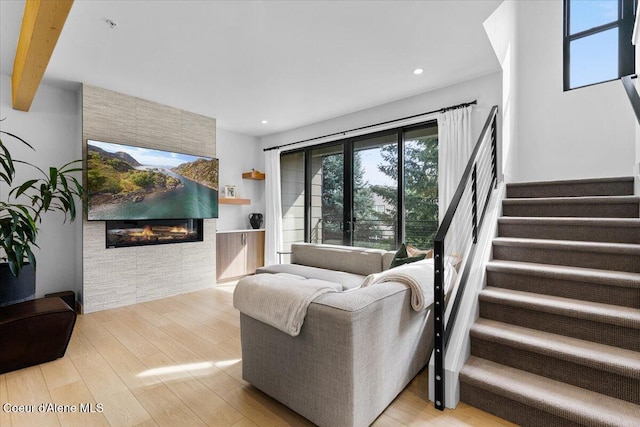 living room featuring beam ceiling and light hardwood / wood-style floors