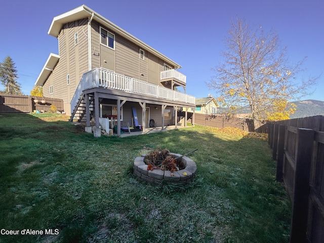 back of house featuring a patio area, a deck, and a lawn