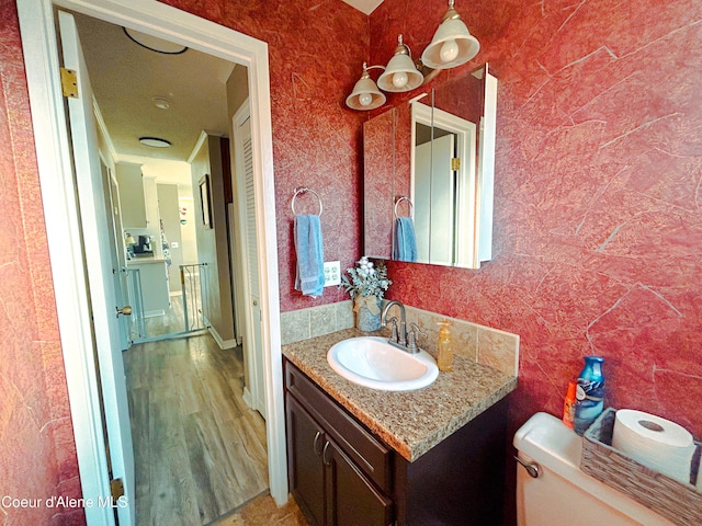 bathroom with vanity, toilet, and wood-type flooring