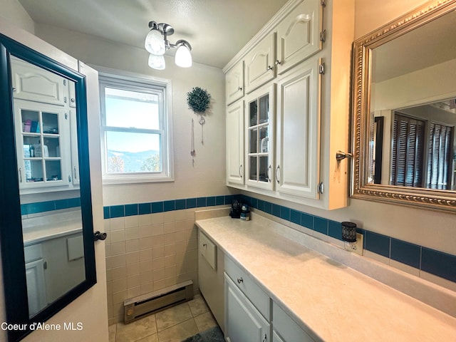 bathroom with tile walls, tile patterned floors, vanity, and a baseboard heating unit