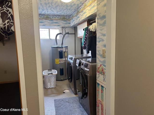 washroom with tile patterned floors, water heater, and washing machine and clothes dryer