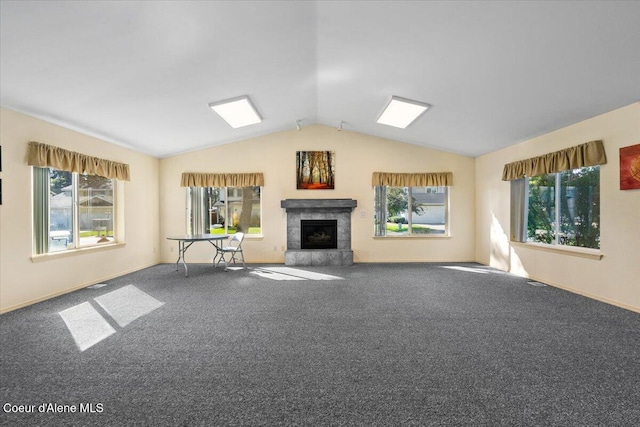 unfurnished living room featuring a tile fireplace, lofted ceiling, carpet, and a healthy amount of sunlight