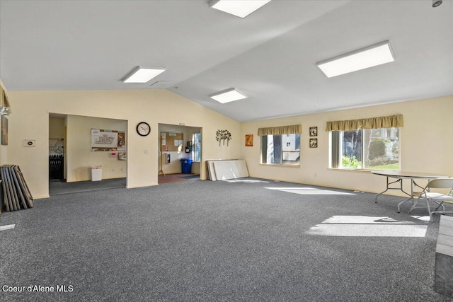 interior space featuring vaulted ceiling and dark colored carpet