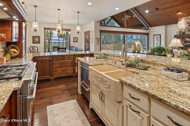 kitchen featuring a wealth of natural light, light stone counters, and vaulted ceiling