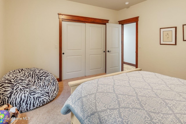 bedroom with light colored carpet and a closet