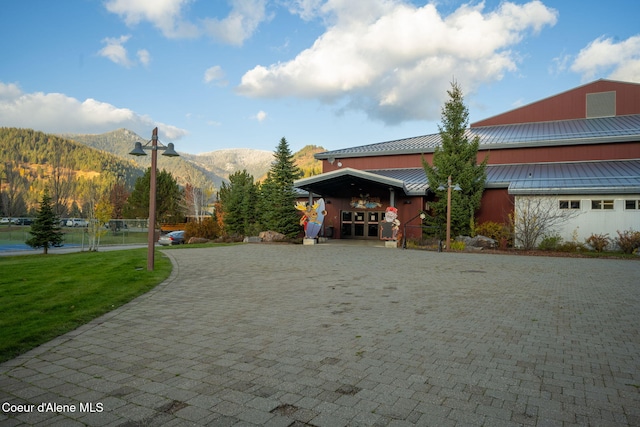 view of front facade featuring a front lawn and a mountain view