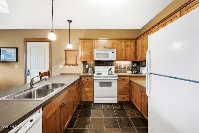 kitchen with hanging light fixtures, white appliances, sink, and decorative backsplash