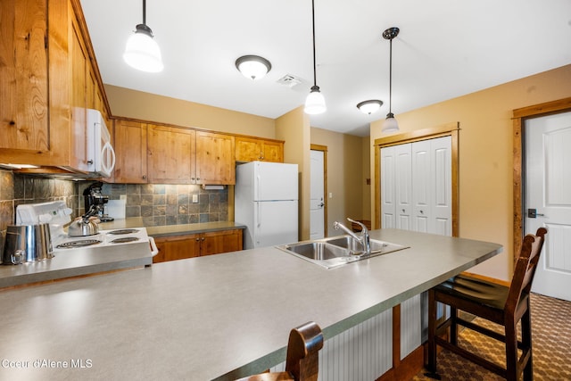 kitchen featuring tasteful backsplash, hanging light fixtures, sink, and white appliances