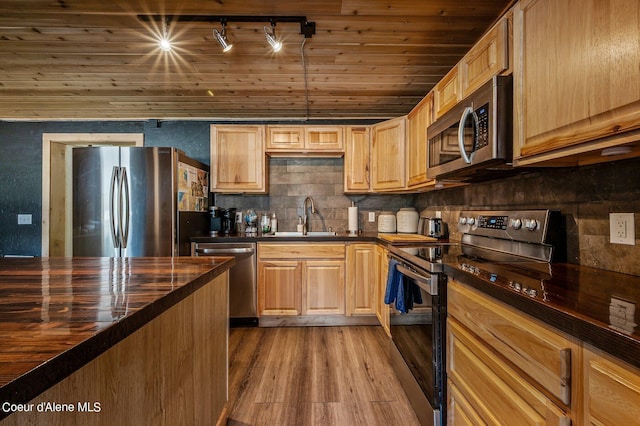 kitchen with stainless steel appliances, wood ceiling, hardwood / wood-style floors, track lighting, and sink