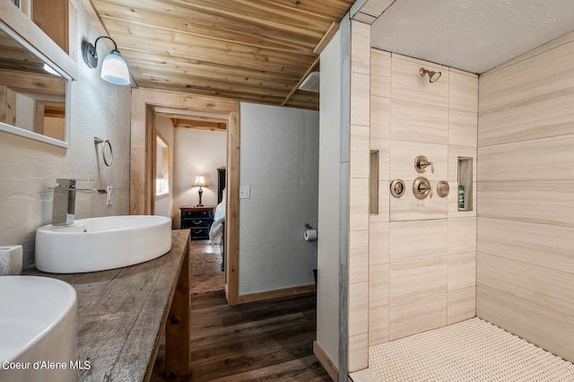 bathroom featuring hardwood / wood-style floors, wood ceiling, sink, and tiled shower