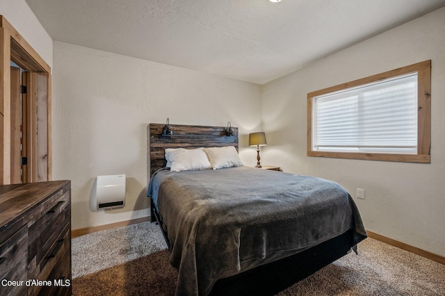 bedroom with heating unit and carpet flooring