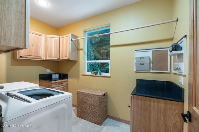 laundry room with separate washer and dryer, light tile patterned flooring, and cabinets