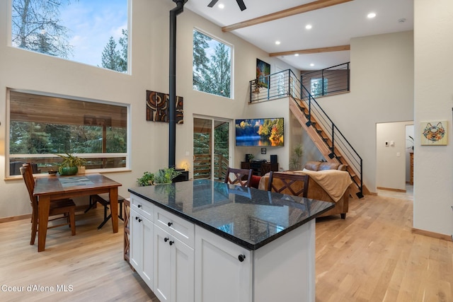 kitchen featuring a wealth of natural light, white cabinetry, dark stone countertops, and light hardwood / wood-style floors