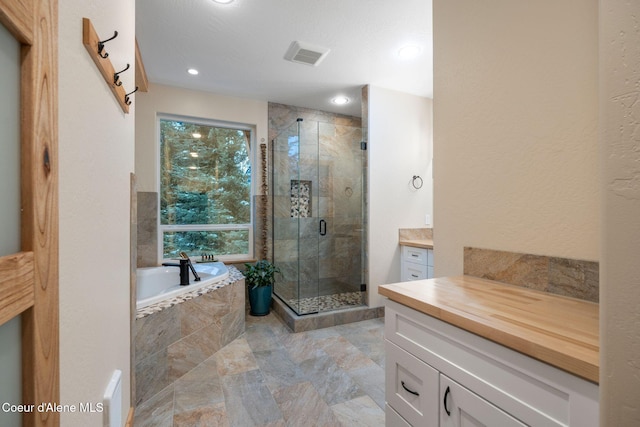 bathroom with vanity, independent shower and bath, and a textured ceiling