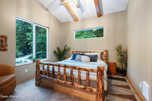 bedroom featuring multiple windows, ceiling fan, and vaulted ceiling with beams