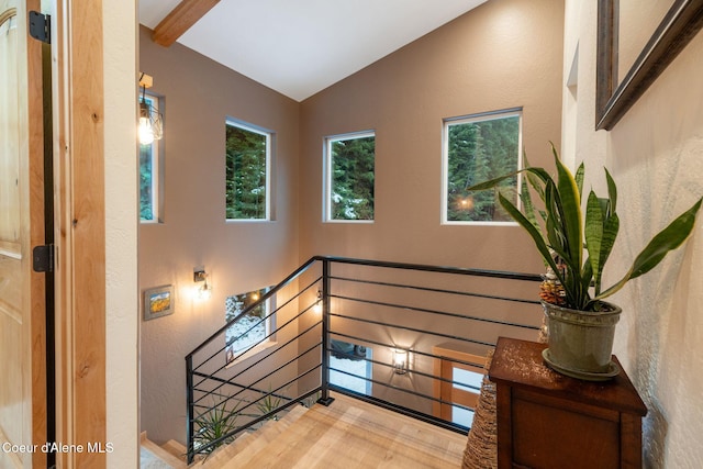 stairway with vaulted ceiling with beams