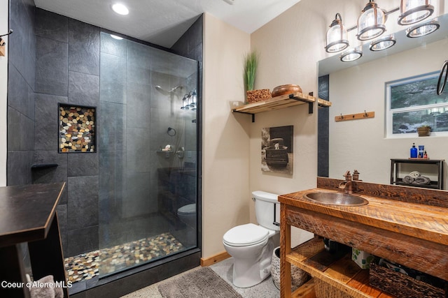 bathroom with toilet, a shower with shower door, and sink