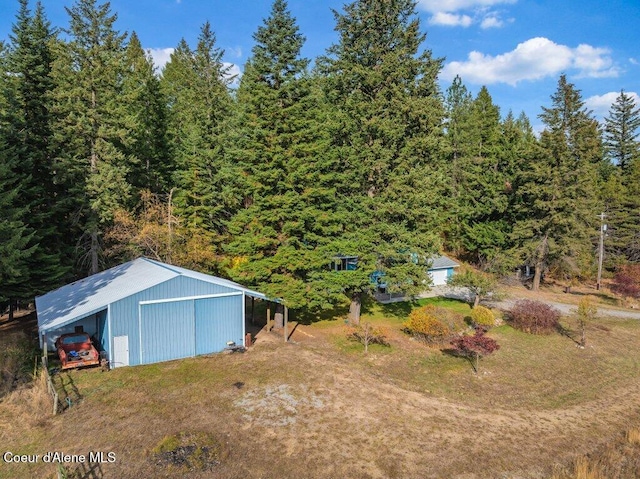 14895 N Crystal Springs Ln, Rathdrum, ID 83858 - view of yard featuring an outbuilding, a garage, an outdoor structure, and a forest view