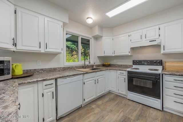 14895 N Crystal Springs Ln, Rathdrum, ID 83858 - kitchen featuring electric range, dishwasher, under cabinet range hood, a sink, and white cabinetry