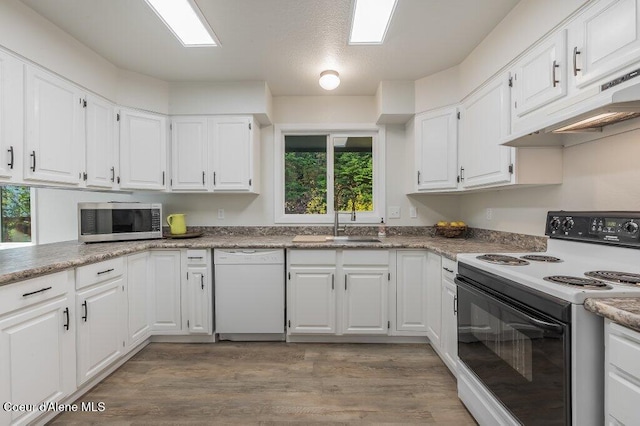 14895 N Crystal Springs Ln, Rathdrum, ID 83858 - kitchen featuring electric range oven, white dishwasher, stainless steel microwave, a sink, and white cabinetry