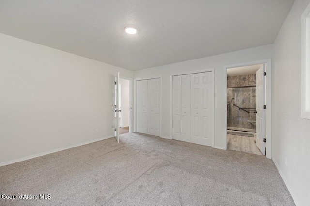 14895 N Crystal Springs Ln, Rathdrum, ID 83858 - unfurnished bedroom featuring multiple closets, carpet flooring, baseboards, and ensuite bathroom
