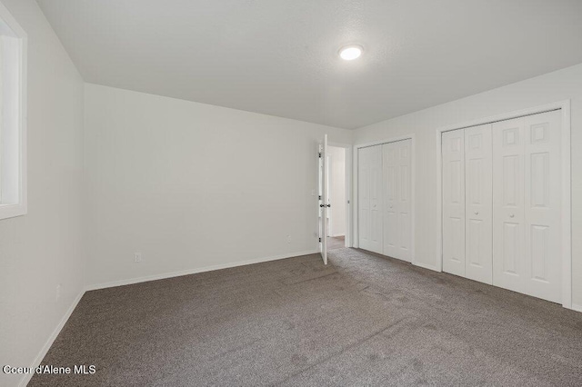 14895 N Crystal Springs Ln, Rathdrum, ID 83858 - unfurnished bedroom with multiple closets, carpet flooring, and baseboards
