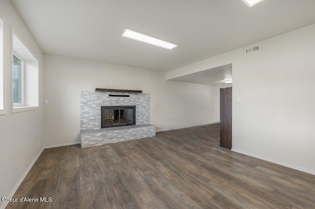 14895 N Crystal Springs Ln, Rathdrum, ID 83858 - unfurnished living room with wood finished floors, a stone fireplace, and baseboards