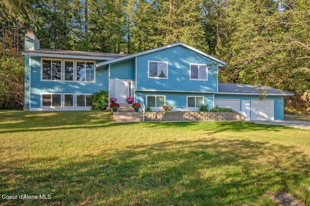 14895 N Crystal Springs Ln, Rathdrum, ID 83858 - bi-level home with a chimney, a front yard, an attached garage, and driveway