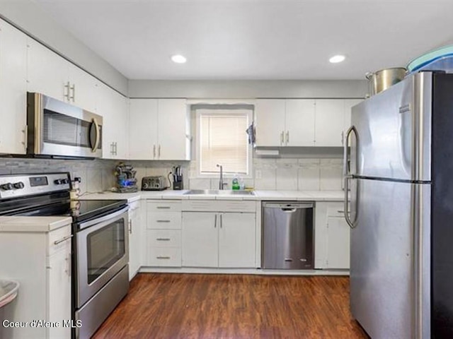 kitchen with dark hardwood / wood-style floors, white cabinetry, sink, and appliances with stainless steel finishes