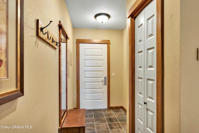 doorway to outside featuring a textured ceiling