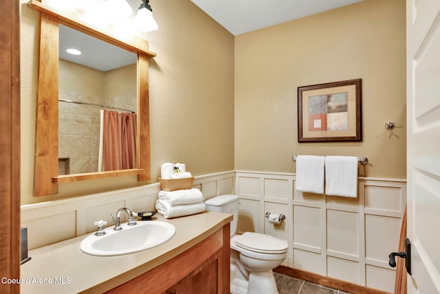 bathroom featuring toilet, walk in shower, tile patterned floors, and vanity