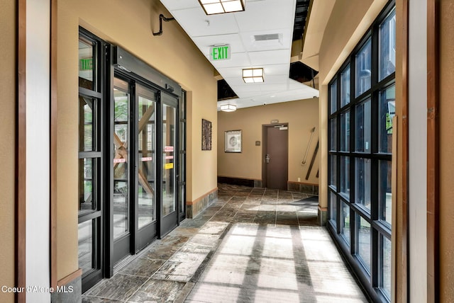 hall with a paneled ceiling