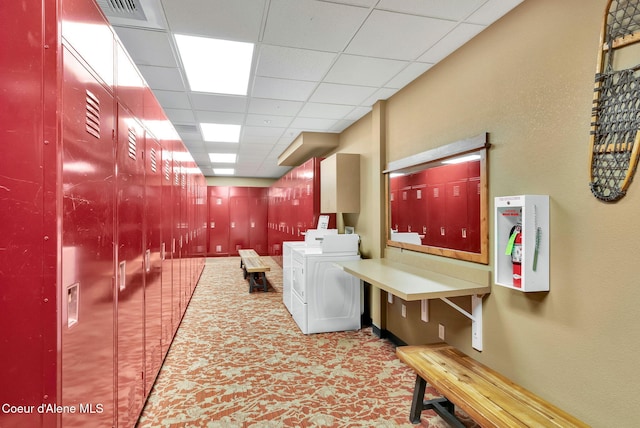 washroom with washing machine and dryer and cabinets