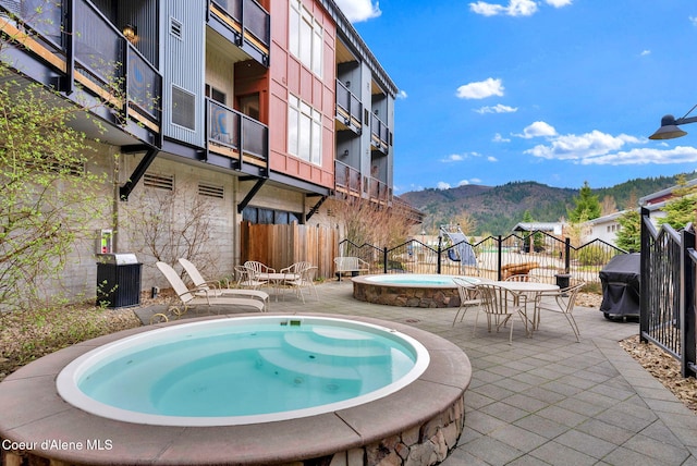 view of pool featuring central air condition unit, a patio, a mountain view, and an in ground hot tub