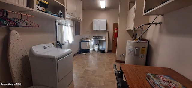 clothes washing area with cabinets, water heater, and washer / clothes dryer