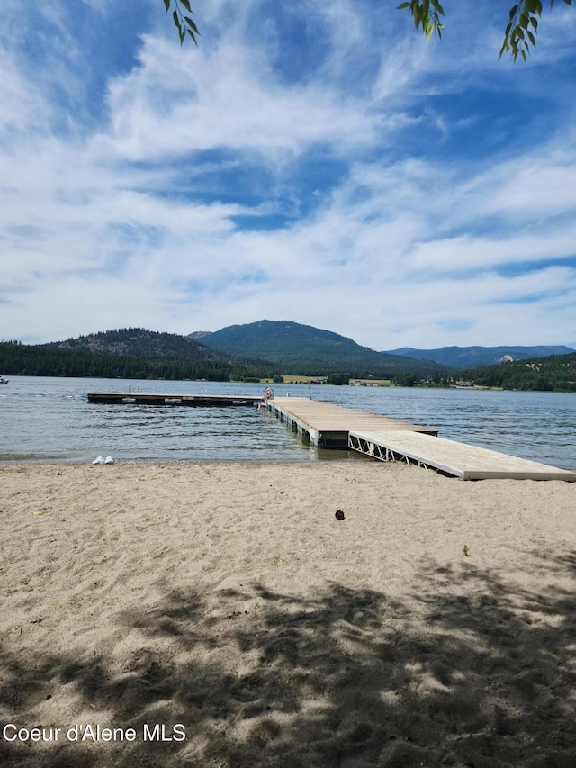 water view with a mountain view and a dock