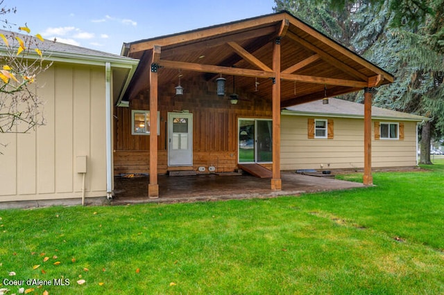 rear view of property featuring a yard and a patio