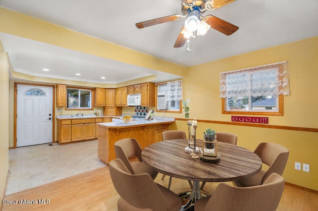 dining area featuring ceiling fan, sink, and light hardwood / wood-style floors