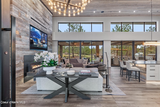 living room featuring a high ceiling, a chandelier, hardwood / wood-style floors, and a fireplace