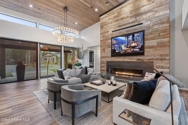 living room with hardwood / wood-style flooring, wood ceiling, a large fireplace, and high vaulted ceiling