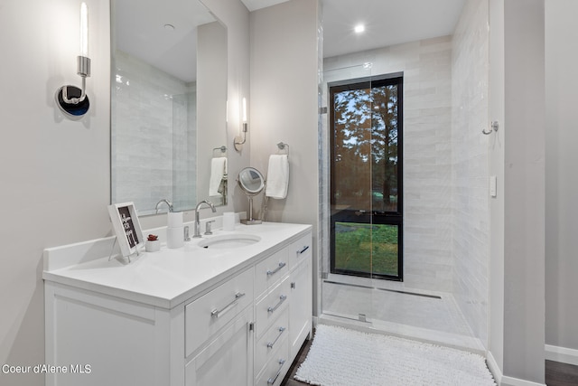 bathroom with tiled shower and vanity