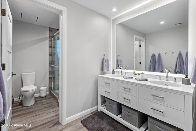 bathroom featuring toilet, vanity, hardwood / wood-style floors, and walk in shower