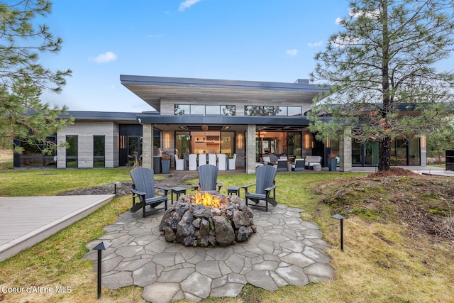 back of property featuring an outdoor living space with a fire pit, a patio, and a yard