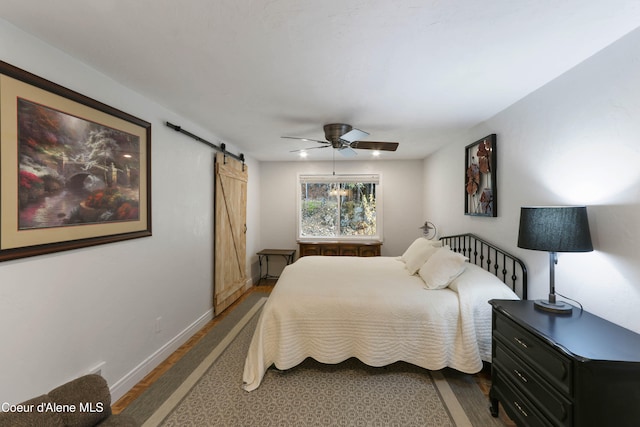 bedroom with a barn door and ceiling fan