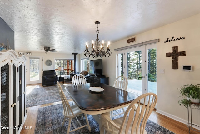 431 E Sunnyside Rd, Sandpoint, ID 83864 - dining space with hardwood / wood-style flooring, french doors, a chandelier, baseboards, and a ceiling fan