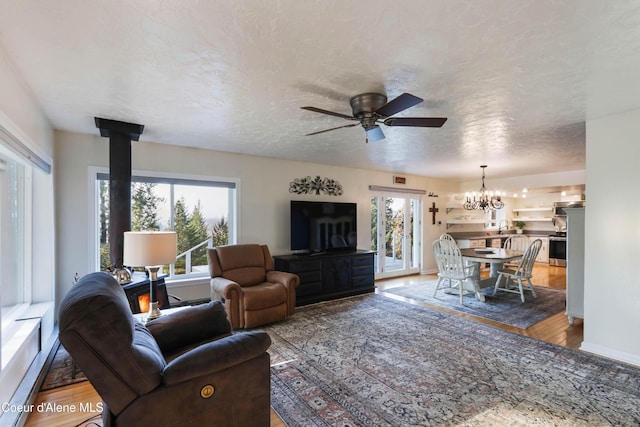 431 E Sunnyside Rd, Sandpoint, ID 83864 - living room with wood finished floors, a chandelier, and a ceiling fan