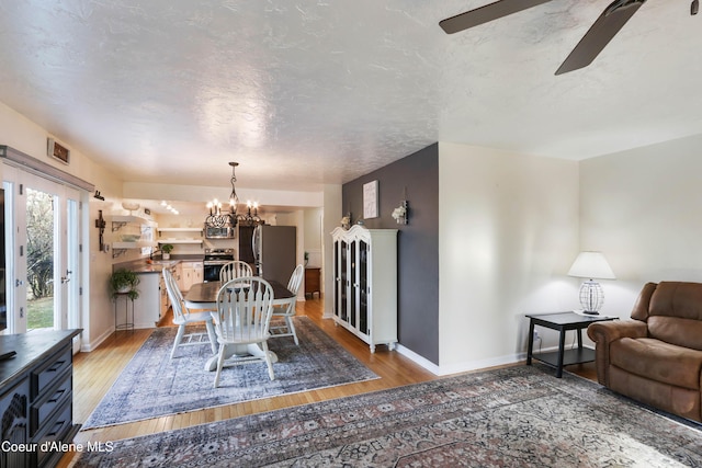 431 E Sunnyside Rd, Sandpoint, ID 83864 - dining area with ceiling fan, light wood-style flooring, baseboards, and a chandelier