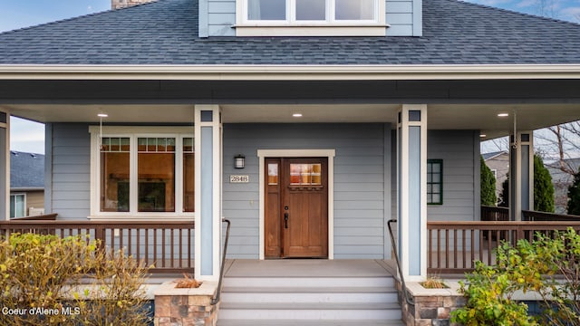 2848 N O Connor Blvd, Post Falls, ID 83854 - view of exterior entry featuring a chimney, roof with shingles, and covered porch
