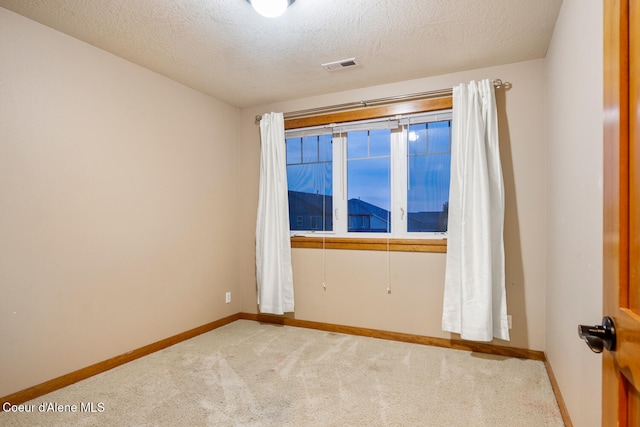 carpeted spare room featuring a textured ceiling